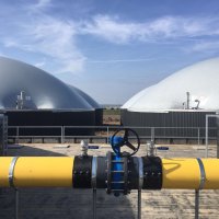 De vergisters met op de voorgrond de gasleiding waardoor het biogas stroomt.