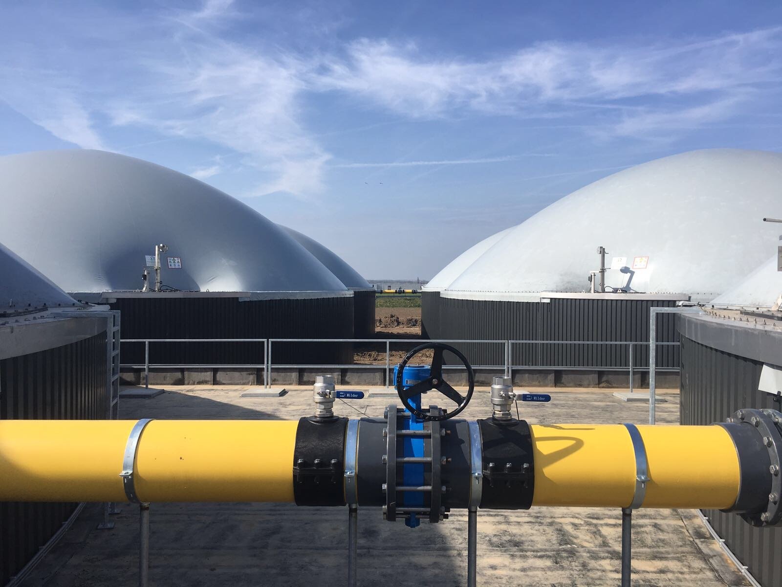 De vergisters met op de voorgrond de gasleiding waardoor het biogas stroomt.